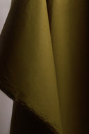 Détail des plis du tissu coton déperlant kaki, texture serrée et légèrement satinée.