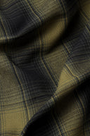 Tissu Le Carreau 004 kaki et anthracite à carreaux façon tartan ombré, plié à plat, lisière effilochée visible.