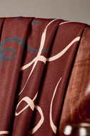 Chaise vintage en bois entièrement recouverte du tissu Misty bordeaux à motif de lignes sinueuses ivoire et marine.