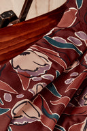 Chaise vintage en bois entièrement recouverte du tissu Peony terracotta à grandes fleurs graphiques.