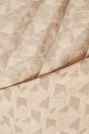 Vue macro de la texture jacquard rose poudré à motif géométrique et fils métallisés.