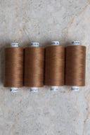 Lot de 4 bobines de fil pour surjeteuse Havana Brown marron caramel alignées – Atelier Brunette