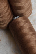 Gros plan sur des bobines de fil pour surjeteuse Havana Brown marron caramel empilées – Atelier Brunette