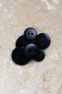 Close-up of the same buttons on the edge of a marbled beige stone.