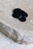 Top-down view of the buttons, stacked at the centre of a marbled beige stone.
