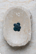 Top-down view of the buttons, stacked at the centre of a marbled beige stone.