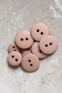 Close-up of the same buttons on the edge of a marbled beige stone.