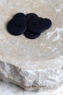 Top-down view of the buttons, stacked at the centre of a marbled beige stone.