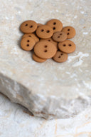 Close-up of the same buttons on the edge of a marbled beige stone.