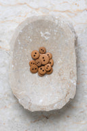 Top-down view of the buttons, stacked at the centre of a marbled beige stone.