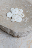 Top-down view of the buttons, stacked at the centre of a marbled beige stone.