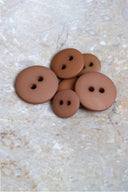Close-up of the same buttons on the edge of a marbled beige stone.