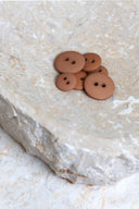 Top-down view of the buttons, stacked at the centre of a marbled beige stone.