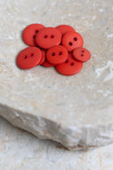 Top-down view of the buttons, stacked at the centre of a marbled beige stone.