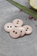 Close-up of the same buttons on the edge of a marbled beige stone.