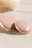 Vue macro très rapprochée sur les boutons, avec un arrière-plan flou évoquant le décor floral de la mise en scène.