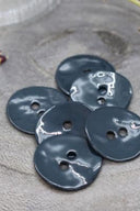 Gros plan sur les mêmes boutons en émail brillant, vue rapprochée révélant la texture lisse et la brillance de la matière.