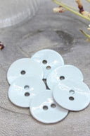 Close-up of the same glossy enamel buttons, revealing the smooth texture and shine of the material.