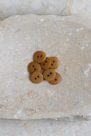 Close-up of the same buttons on the edge of a marbled beige stone.