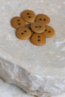 Top-down view of the buttons, stacked at the centre of a marbled beige stone.