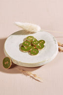 Close-up of the same round buttons rimmed with a gold trim, highlighting the shine of the enamel.