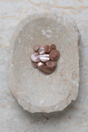 Close-up of the same buttons on the edge of a marbled beige stone.