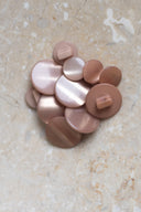 Top-down view of the buttons, stacked at the centre of a marbled beige stone.