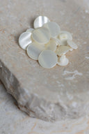 Top-down view of the buttons, stacked at the centre of a marbled beige stone.