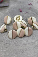 Close-up of the same two-tone buttons, highlighting the gold edge separating the two shades.