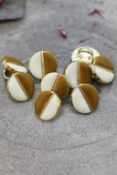 Close-up of the same two-tone buttons, highlighting the gold edge separating the two shades.