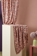Close-up of the folds of the Fuji fabric in powder pink, revealing the detail of the terracotta and navy blue strokes.