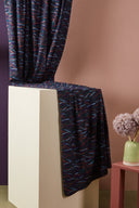 Close-up of the folds of the Fuji fabric in anthracite, revealing the detail of the orange and sky blue strokes.