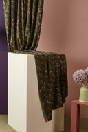Close-up of the satin folds of the Java fabric in khaki with a confetti pattern in pink, blue and plum.