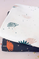 Palmetto fabrics in ivory and navy folded together, showing the same palm-leaf pattern in both colorways from the collection.