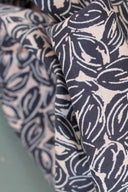 Tissus Petal pliés côte à côte, motif de cercles entrelacés en deux coloris, marine et écru sur fond taupe, et marine sur fond écru.