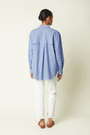 Boyish Shirt pattern – back view, shirt blue chambray, round pleat on the back, white trousers – Atelier Brunette