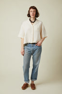 Short-sleeved Shirt pattern (envelope) – front view, short-sleeved shirt crème, blouse collar, pearl necklace, jeans – Atelier Brunette
