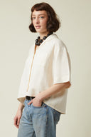 Short-sleeved Shirt pattern (envelope) – front view slight, short-sleeved shirt crème, hand in pocket, jeans – Atelier Brunette