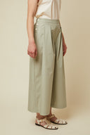 Patron Jupe Culotte – vue 3/4 gauche, jupe culotte vert sauge, patte boutonnage visible, sandales blanches – Atelier Brunette