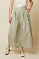 Patron Jupe Culotte – vue de face, jupe culotte vert sauge, t-shirt blanc, main dans poche, plis devant – Atelier Brunette