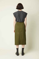 Patron Jupe Défendue – vue de dos, jupe midi kaki, fermeture zip invisible, t-shirt gris, bottes noires – Atelier Brunette