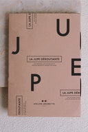 Patron Jupe Déroutante – Étui patron kraft rose LA JUPE DÉROUTANTE, logo Atelier Brunette, fond marbre – Atelier Brunette