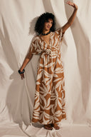 Patron La Robe Butterfly – Femme bras levé, robe caramel motif feuillage, manches kimono, fond rideau – Atelier Brunette