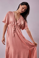 Patron La Robe Butterfly – Femme de face, robe rose poudré portefeuille, manches kimono, fond parme – Atelier Brunette