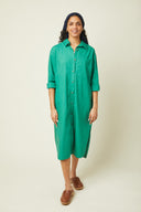 Patron Robe Chemise – Femme de face, robe chemise verte émeraude boutonnée, manches longues, fond beige – Atelier Brunette