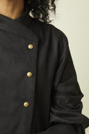 Patron Veste Troublante – vue de face buste, col montant croisé et boutonnage doré, coloris noir – Atelier Brunette