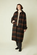 Patron Le Manteau – Femme de face, manteau long tartan brun/noir, col chemise, pull écru – Atelier Brunette