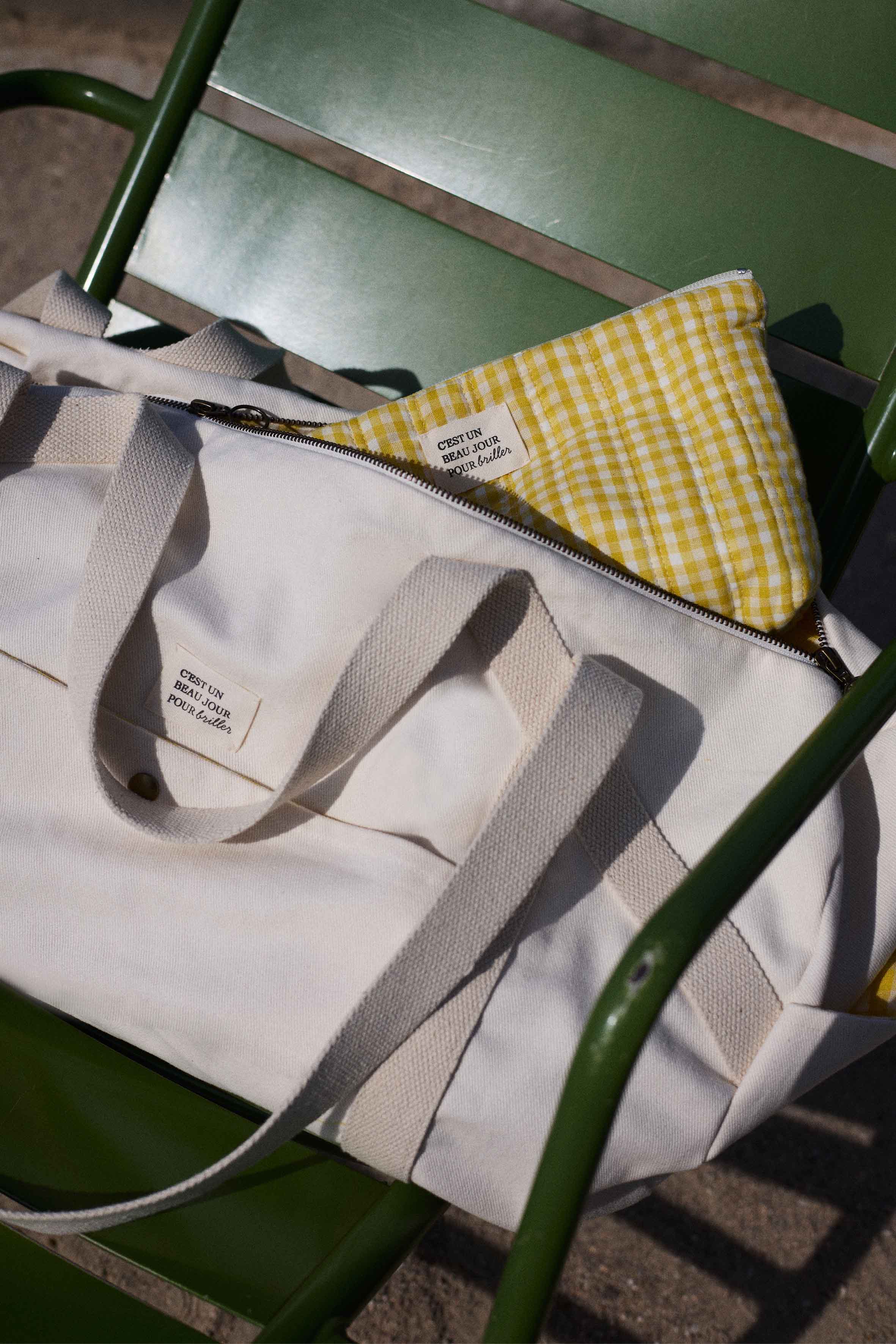 Patron Le Pack Escapade – Sac de voyage et pochette banane vichy jaune, pose sur chaise verte – Atelier Brunette