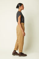 Belted Trousers pattern – Left profile view, carrot trousers camel high waist, top sleeveless grey – Atelier Brunette