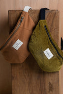 Bum Bag pattern – two bags side by side wood background, caramel velvet and khaki, navy handle – Atelier Brunette